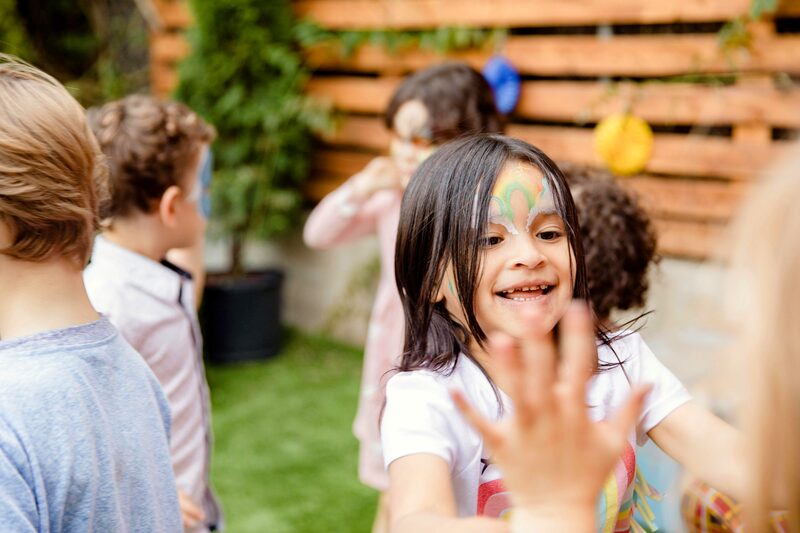 Crianças com pinturas faciais durante uma festa no jardim